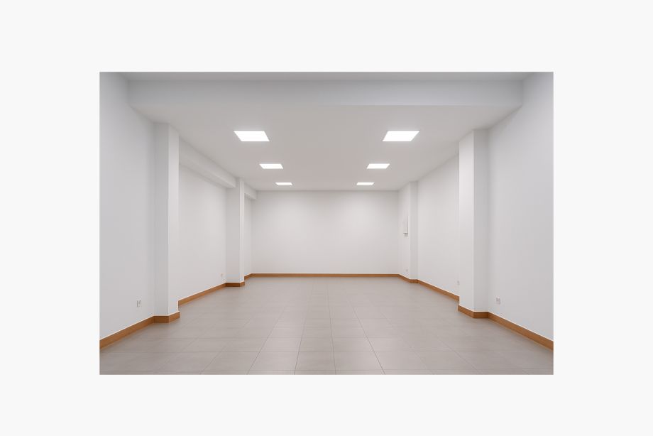 Interior de local comercial vacío con iluminación LED y suelos cerámicos.