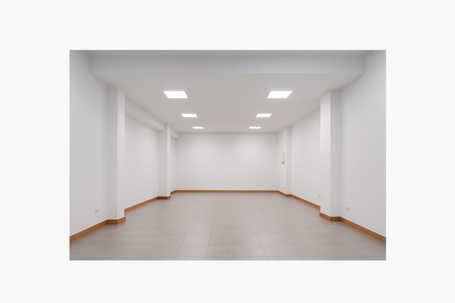 Interior de local comercial vacío con iluminación LED y suelos cerámicos.